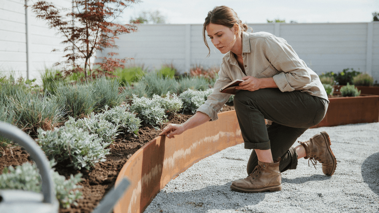 Modern garden border with corten steel edging creating clean sharp lines between gravel and planting areas.